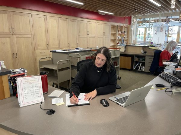 Ashley Wineman working at the front desk of the library. Photo by Noah Morss. 
