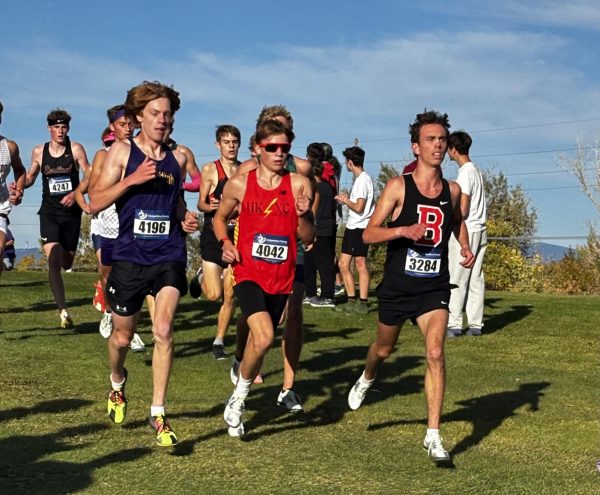 Miles Miller, junior, leads the fastest varsity boy's race at the Helena 7 of 7 meet, with the distinctive HKXC logo worn proudly across his chest. The lightning bolt jersey is a representation of the legacy and enduring strength that characterizes the team. Photo by Sabine Glaser.