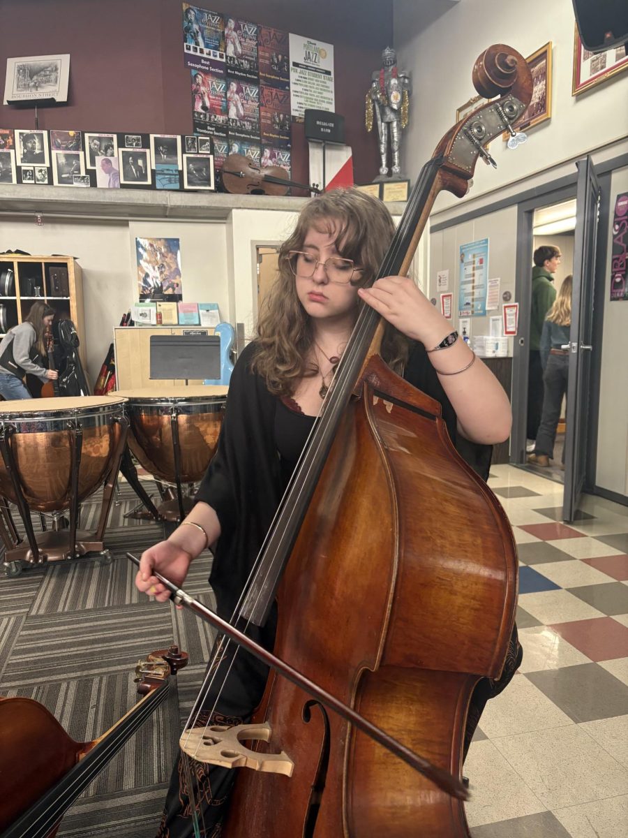 Lenora Sackey tunes their bass before class